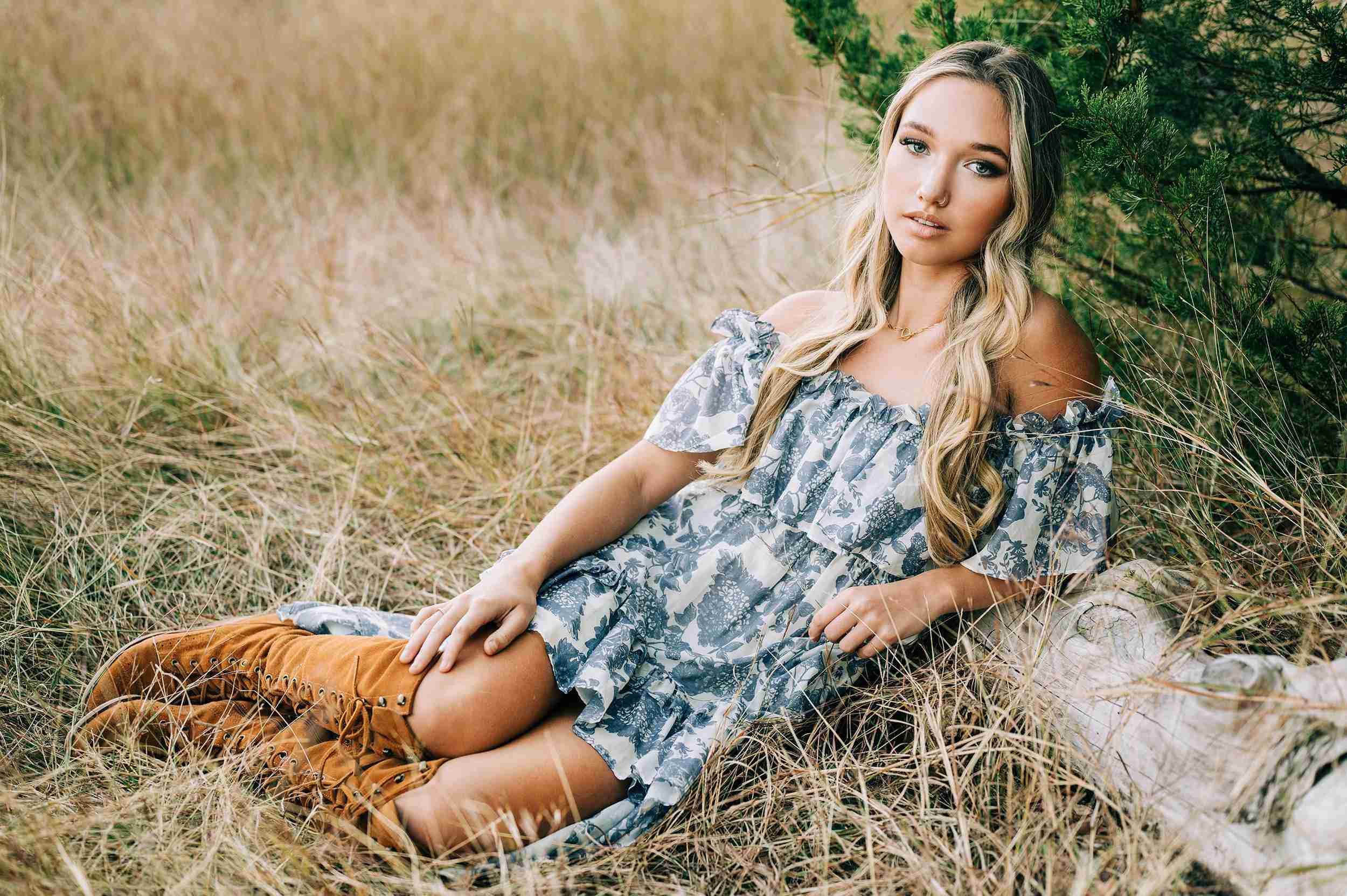 High school senior leaning on a tree looking at the camera