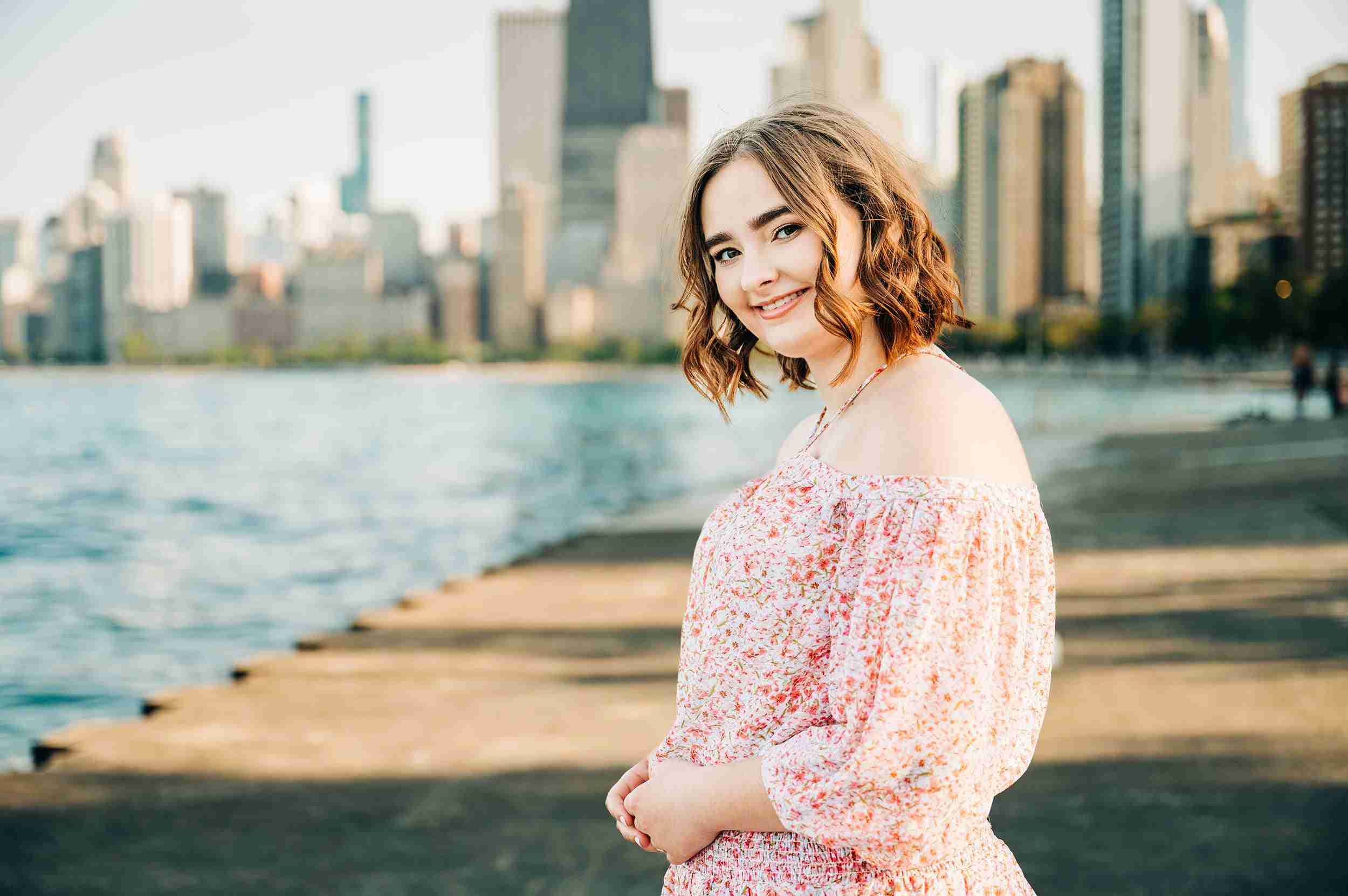 girl pink dress standing at lakefront chicago skyline