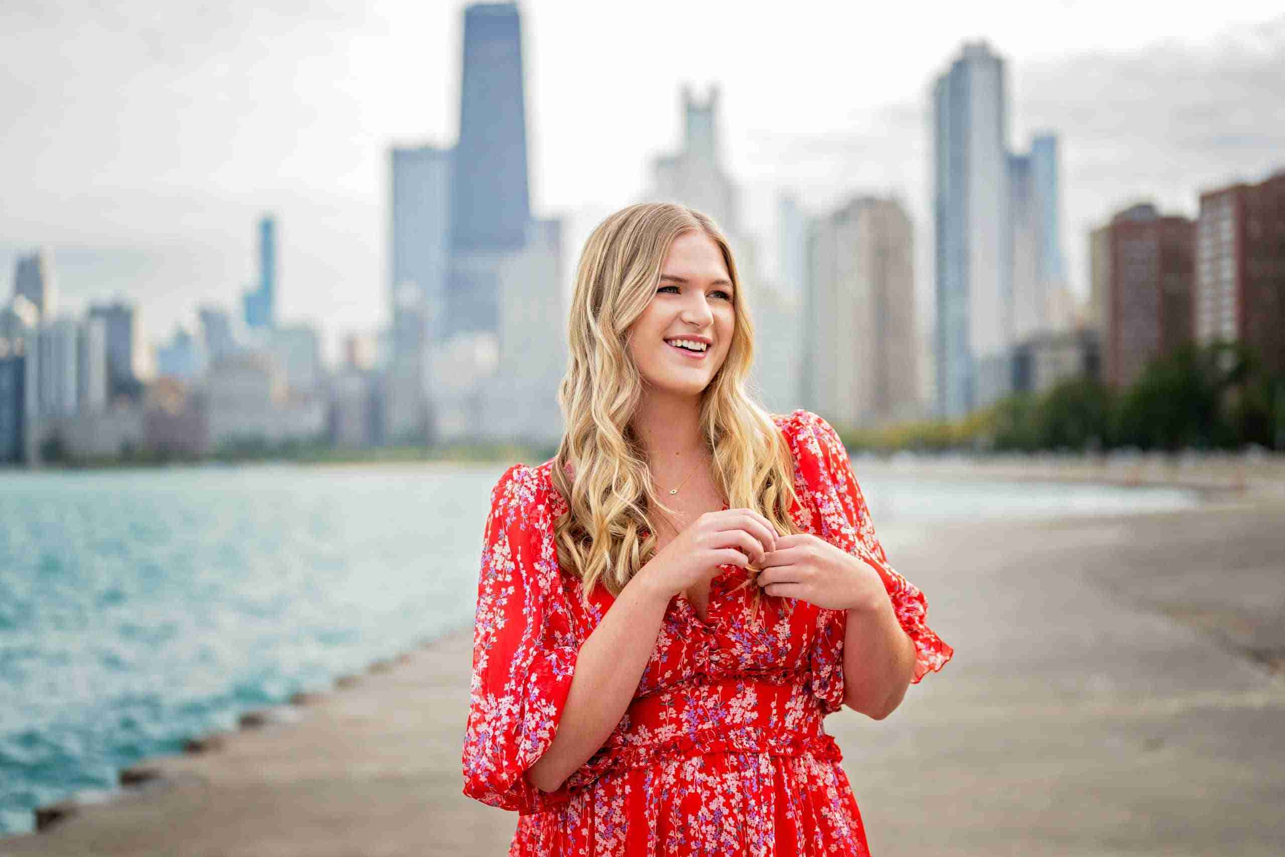 girl in red dress standing at lakefront in front of chicago skyline
