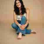 What to Ask Your Senior Photographer Before Booking – senior girl wearing white crochet top sitting on tan studio backdrop, senior girl pose ideas – award-winning Chicago senior photographer Shalimar B. Photography.