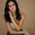 What to Ask Your Senior Photographer Before Booking – senior girl photos in studio wearing white crochet top on tan backdrop– award-winning Chicago senior photographer Shalimar B. Photography.