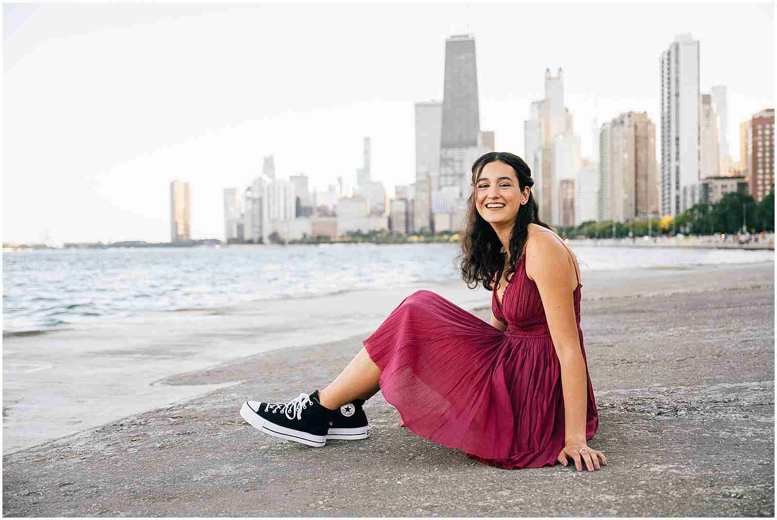 What to Ask Your Senior Photographer Before Booking with award-winning Chicago senior photographer Shalimar B. Photography. North Avenue Beach senior photo inspiration with senior girl wearing red dress and black converse sneakers.